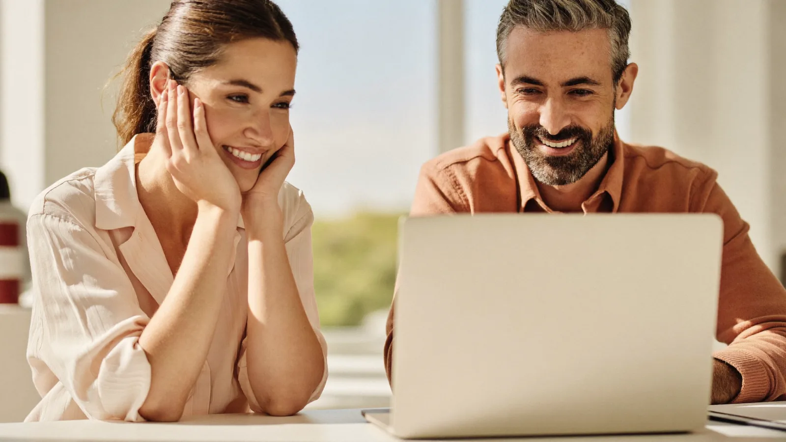 Two professionals collaborating at a laptop